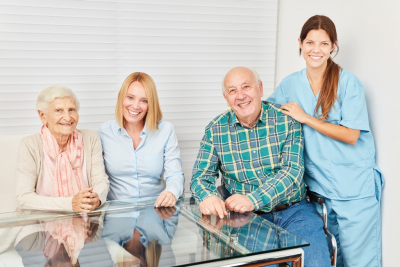 senior couple and their caregiver smiling